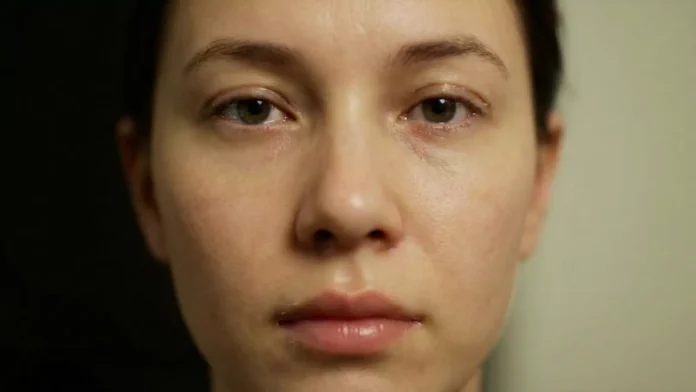 A close-up human face that looks real but slightly unsettling, clearly AI-generated or deepfake-style.